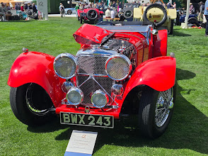 Red classic Jaguar roadster detailed for a Monterey car show, chrome and paint polished
