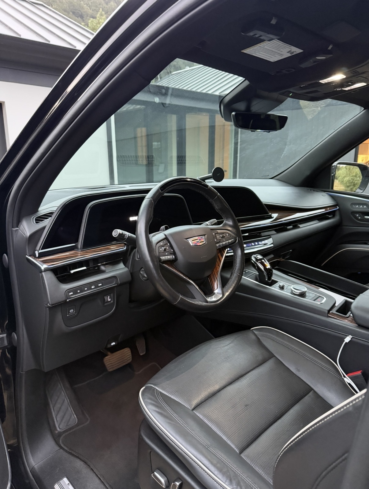Freshly detailed black leather Cadillac SUV interior with clean dashboard, steering wheel and seats