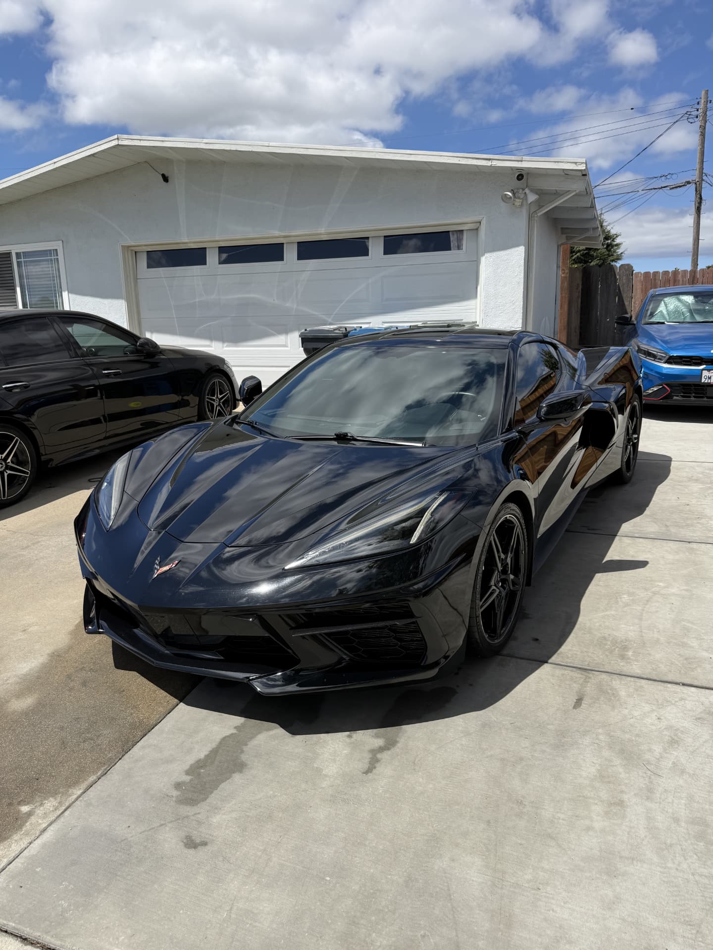 Two-bucket hand wash suds sheeting off a black sedan